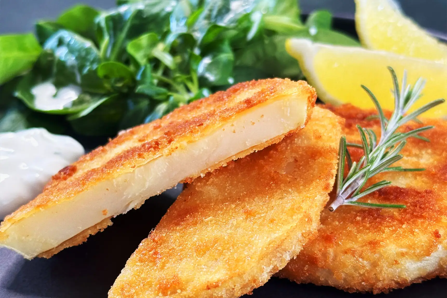 Veganes Sellerieschnitzel mit Salat und Zitrone.